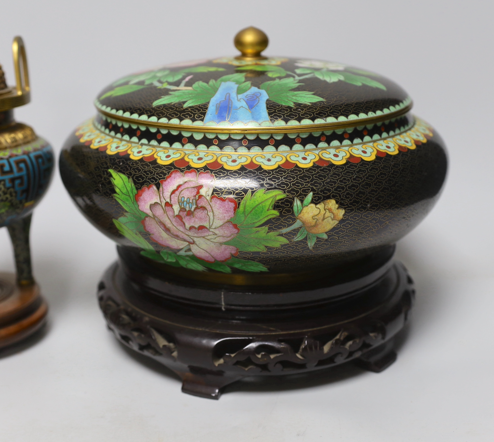 A Chinese cloisonné enamel three footed vase and cover together with a censer and cover, each raised on hardwood stands, the largest 26cm in diameter